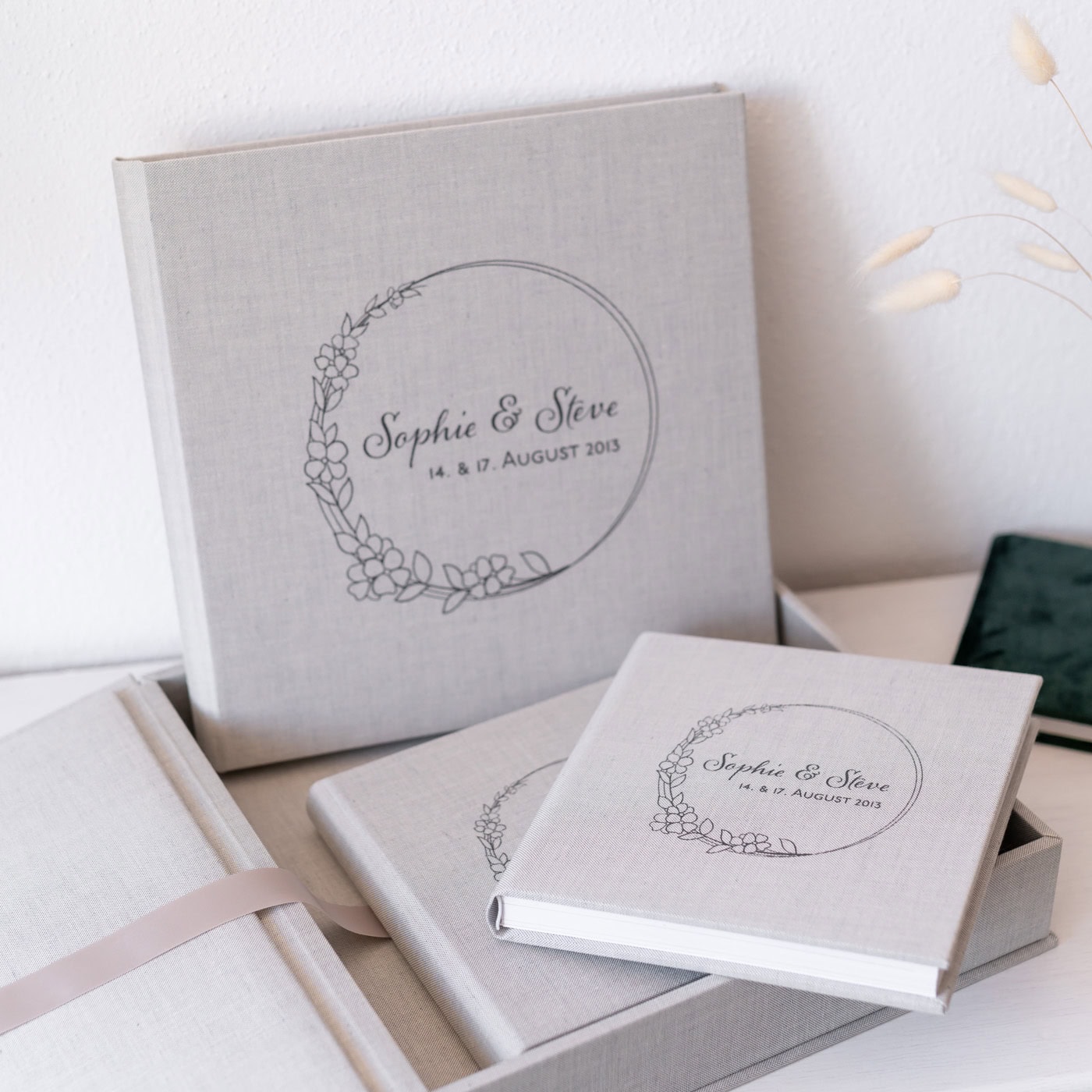 Das Bild zeigt eine Sammlung von personalisierten Stoffalben oder Büchern in einem Leineneinband.