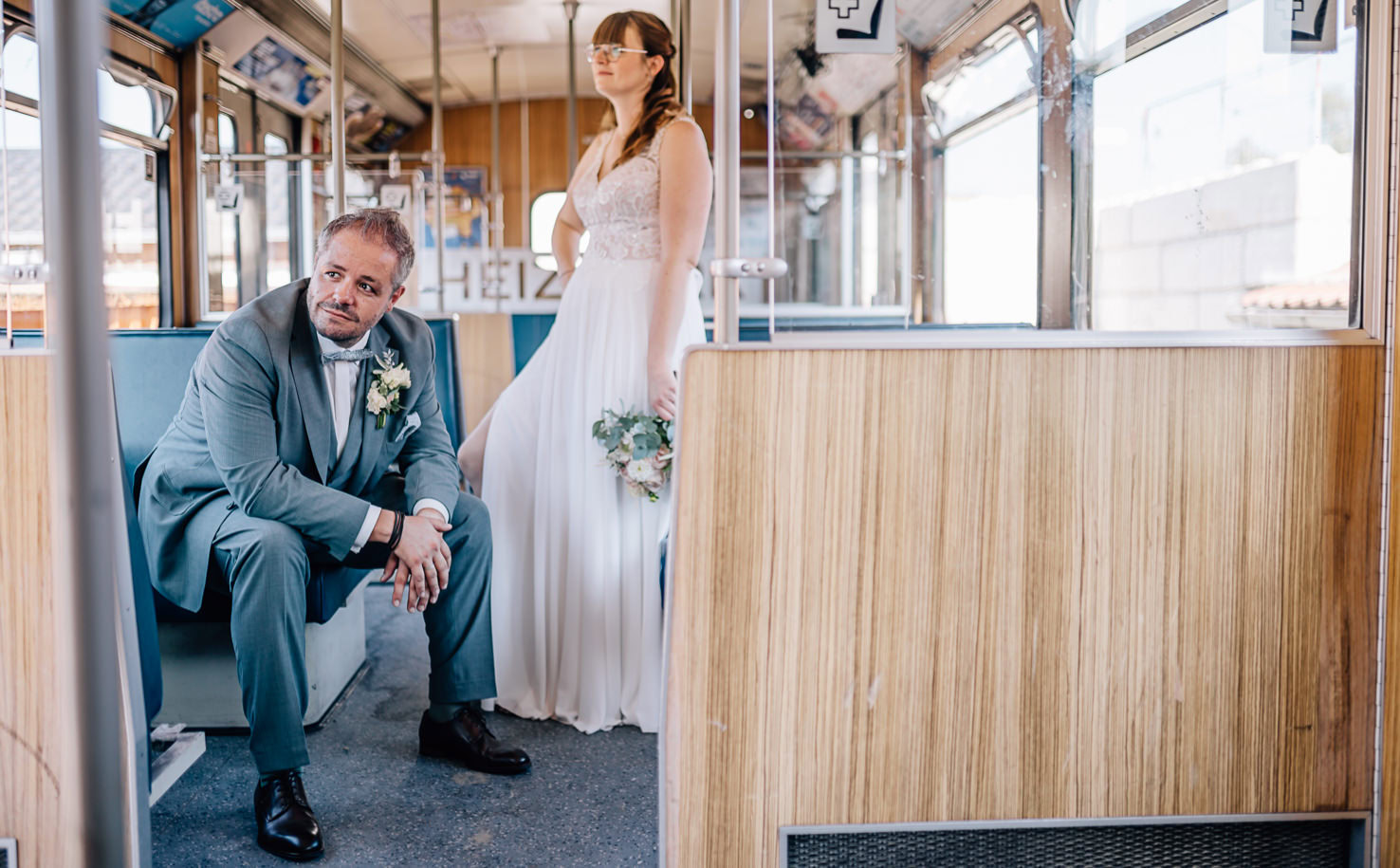 Ein Mann und eine Frau, wahrscheinlich ein Brautpaar, befinden sich in einem Straßenbahnwagen.
