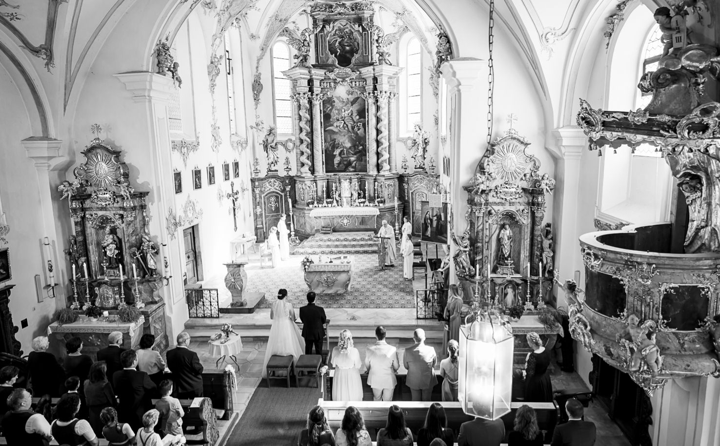 Das Bild zeigt eine Hochzeitszeremonie in einer Kirche.