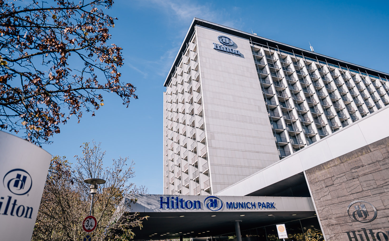 Das ist ein Foto des Hilton Munich Park Hotels an einem sonnigen Tag.