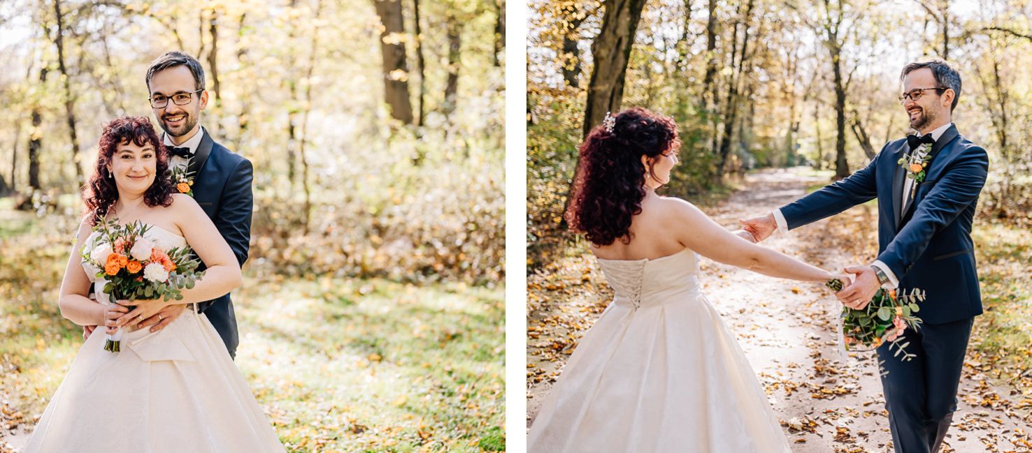 Das Bild zeigt ein Brautpaar in Hochzeitskleidung, das im Wald posiert.