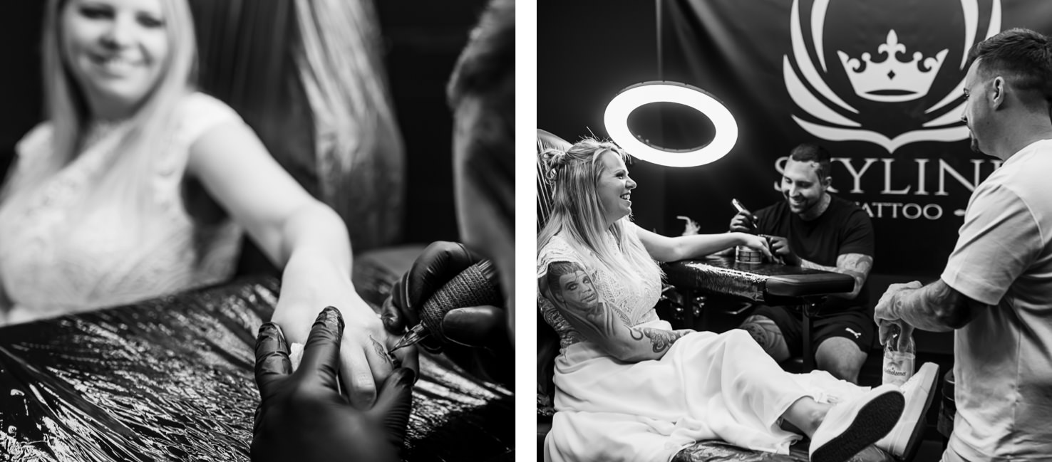 Das eindrucksvolle Schwarz-Weiß-Bild von Mica Zeitz zeigt eine Braut, die sich in einem Tattoo-Studio ihre Haut verzieren lässt, während sie zusammen mit den Tattoowierern lacht und den Moment genießt. Diese einzigartige Verbindung von Hochzeitsfeierlichkeiten und Körperkunst fängt die kreative Atmosphäre und die Freude des Tattoos perfekt ein.