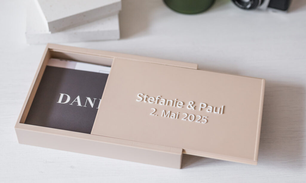 Das stilvolle Hochzeits-Set von Stefanie und Paul, das elegant in einer neutralen Box präsentiert wird, bietet eine zeitlose Möglichkeit zur Dokumentation ihrer Feierlichkeiten am 2. Mai 2025. Dieses ansprechende Design von Fotografin Mica Zeitz kombiniert Ästhetik und Funktionalität und macht es zu einem Must-Have für Bräute und Bräutigame.