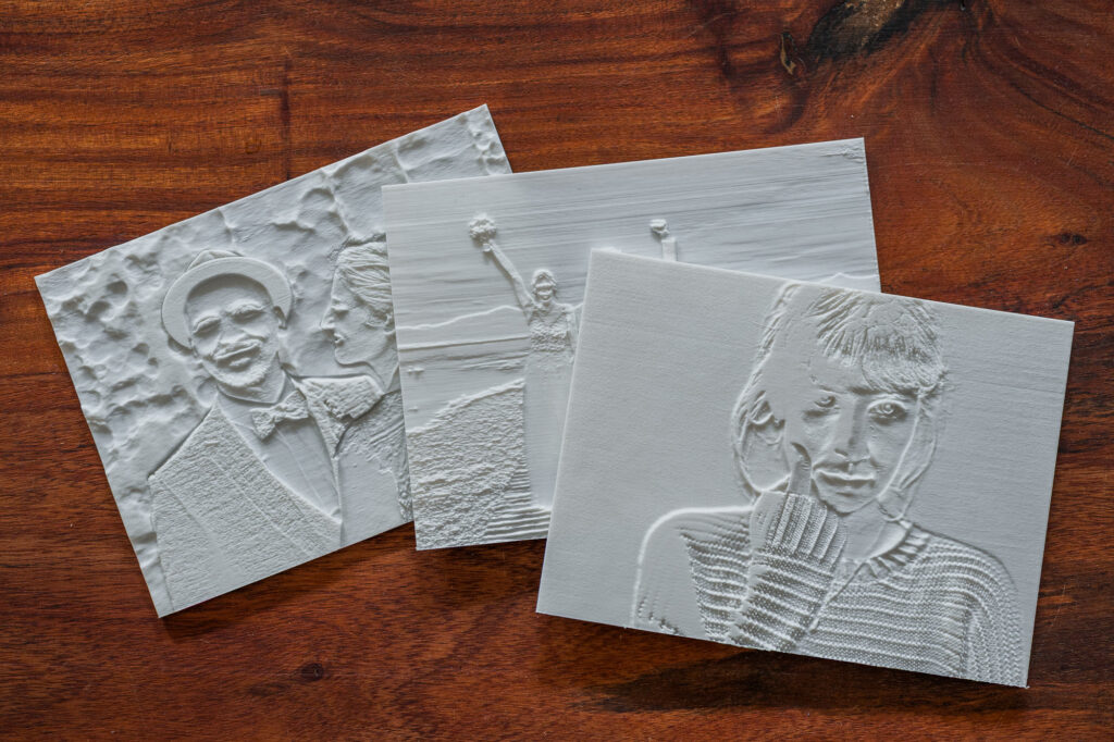 Das Bild zeigt dreidimensionale Reliefs, die aus verschiedenen Fotografien bestehen, und vermittelt eine beeindruckende Verbindung zwischen klassischer Fotografie und moderner Kunst. Die Arbeiten von Fotografin Mica Zeitz reflektieren kreative Techniken zur Darstellung von Emotionen und Erinnerungen durch taktile Elemente.
