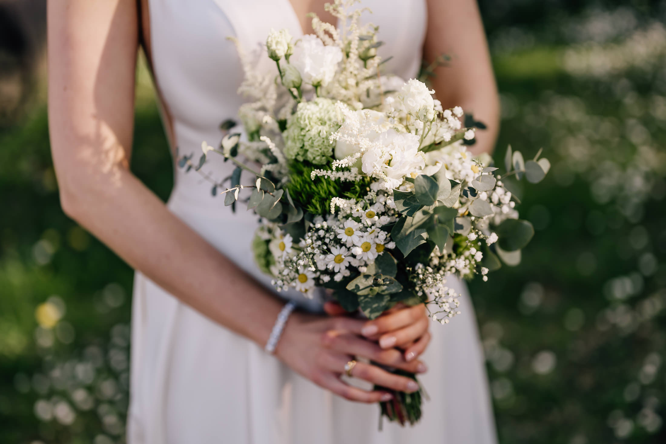 Das Bild zeigt einen hübschen Brautstrauß mit frischen, frühlingshaften Blumen in einer idyllischen Umgebung. Die Aufnahme stammt von der Fotografin Mica Zeitz und fängt die romantische Atmosphäre einer Hochzeit in Eder am Holz perfekt ein.